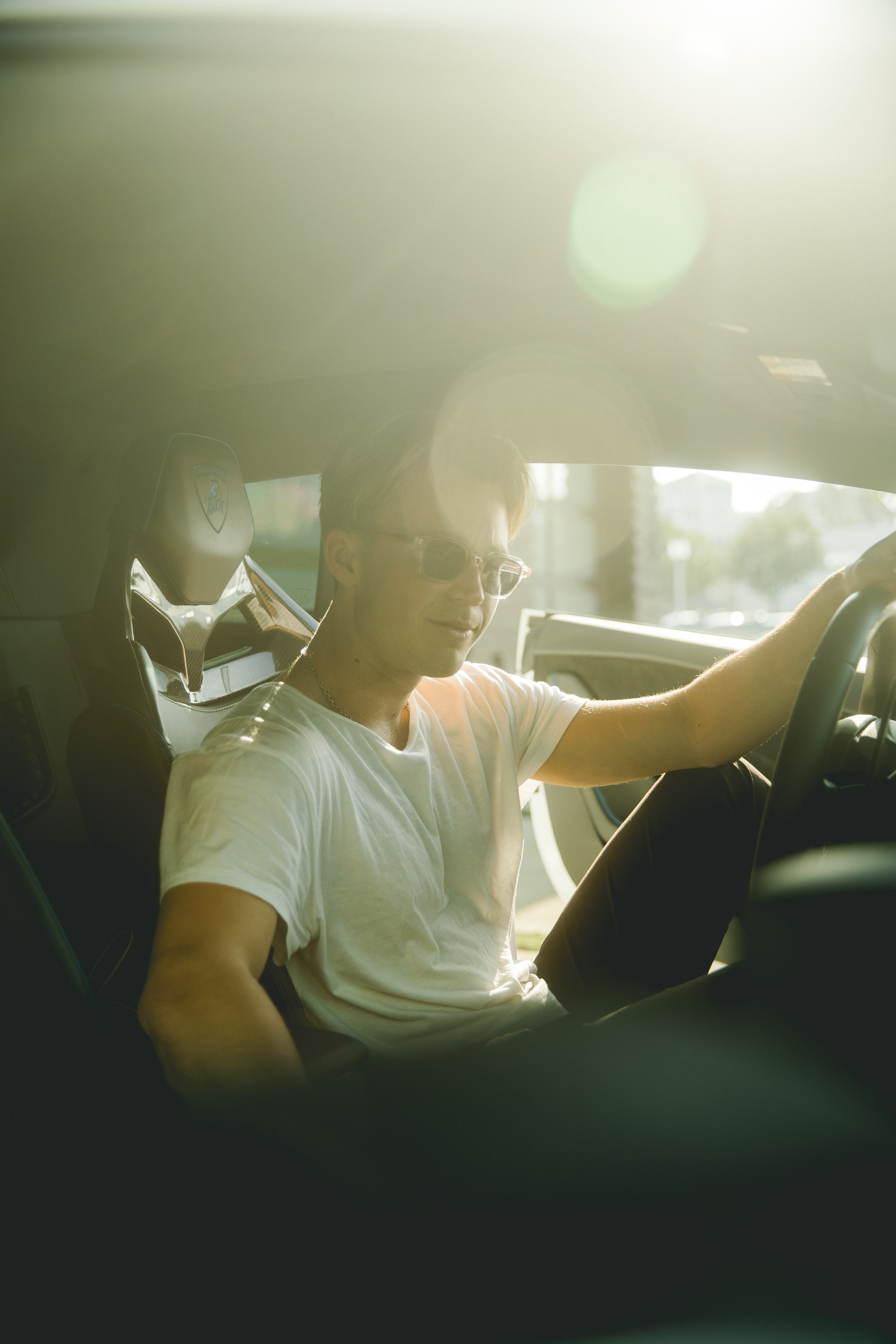 man in white crew neck t-shirt sitting on car seat